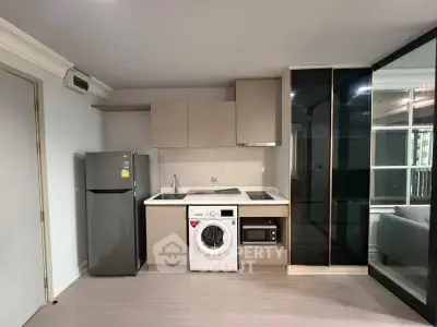 Modern kitchen with sleek appliances and stylish cabinetry in a contemporary apartment.