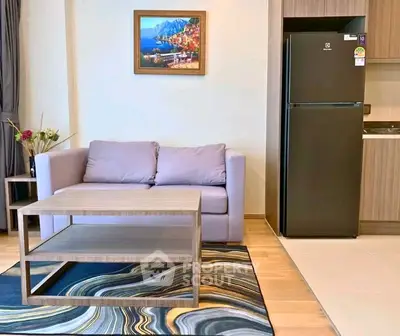 Modern living room with stylish furniture and sleek kitchen area featuring a fridge, perfect for urban living.