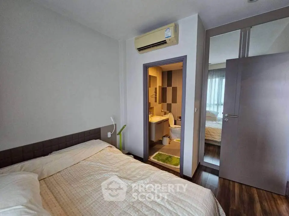 Cozy bedroom with ensuite bathroom and air conditioning in modern apartment.