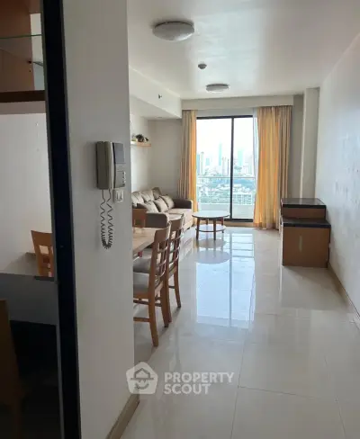 Spacious living room with city view, modern furniture, and natural light.
