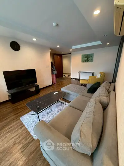 Spacious living room with modern decor and cozy seating area.