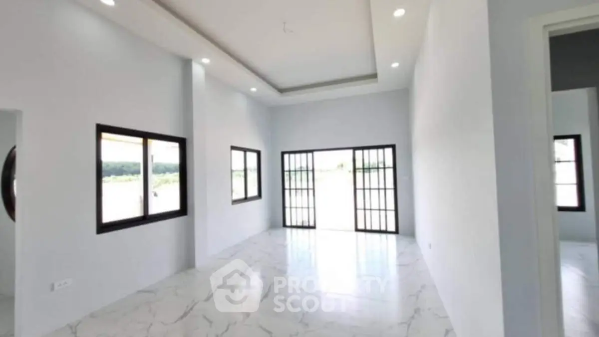Spacious modern living room with large windows and elegant marble flooring