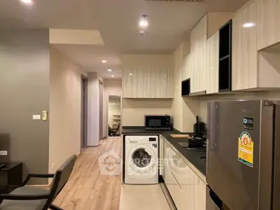 Modern kitchen with sleek appliances and stylish cabinetry in a contemporary apartment.