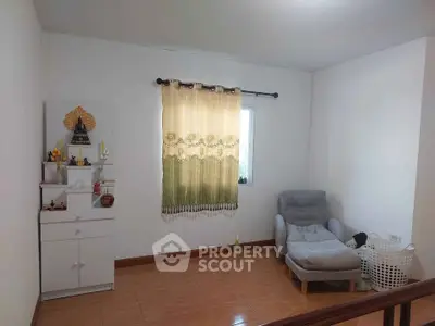 Cozy small living area with armchair and decorative shelf