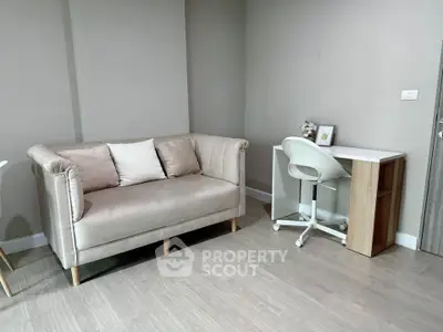 Modern living room with stylish sofa and compact study desk, perfect for urban living.