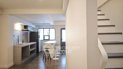 Modern open-plan kitchen with sleek design and stylish staircase