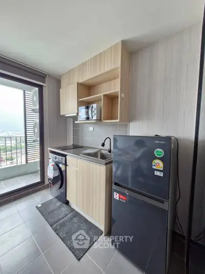 Modern kitchen with sleek appliances and balcony view in a stylish apartment.