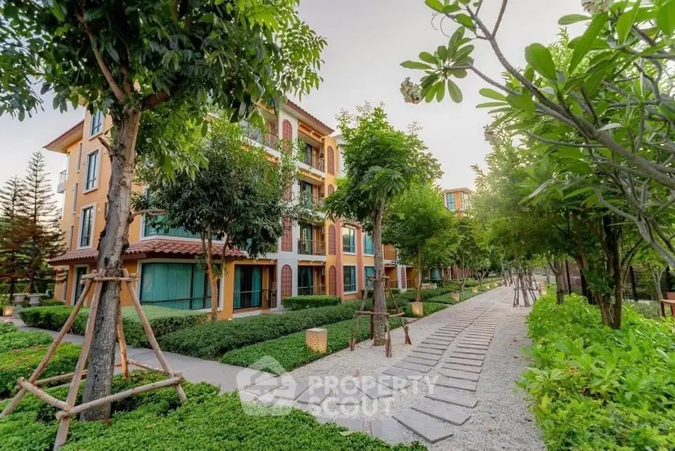 Charming residential building with lush green landscaping and serene walkway