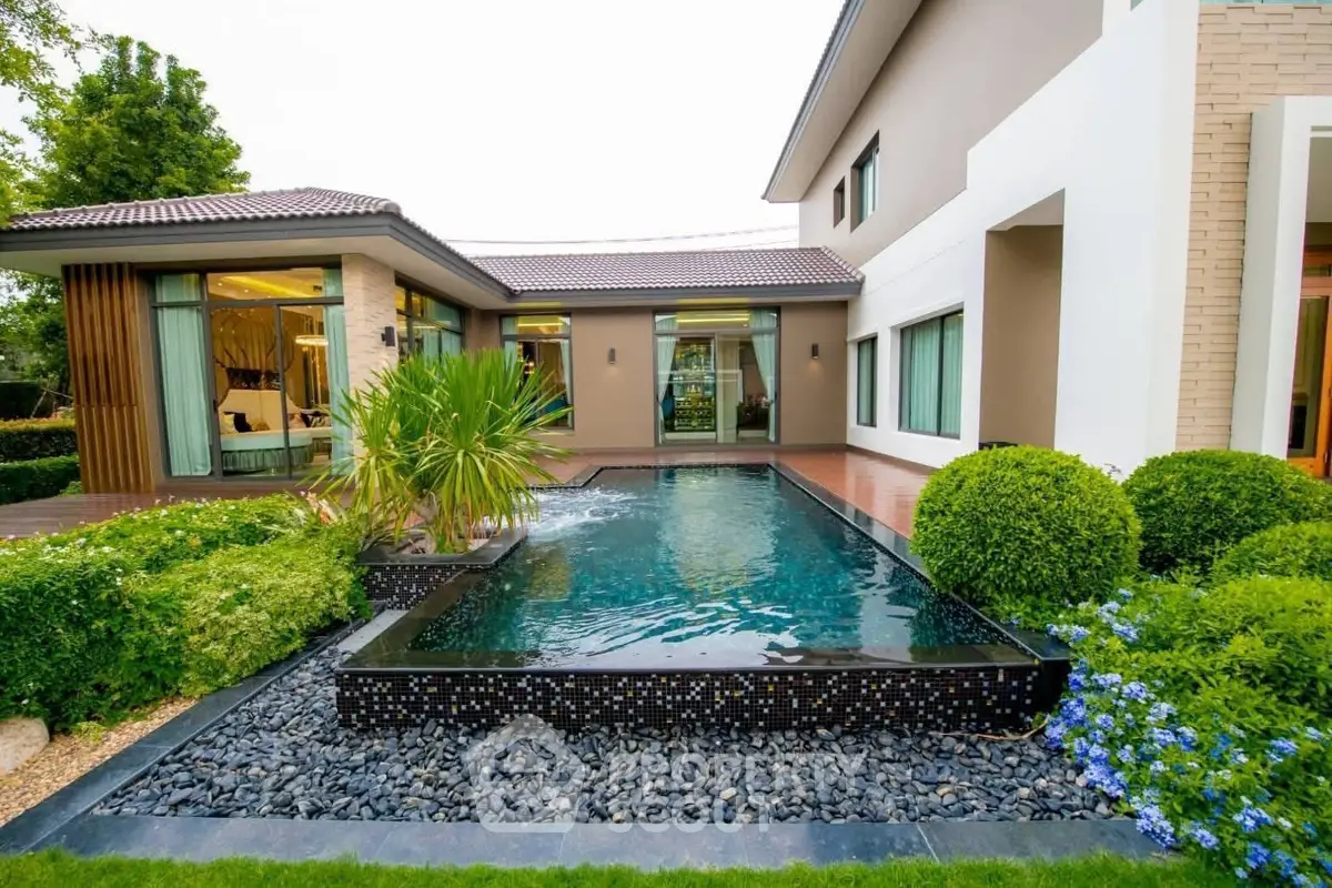 Luxurious modern home with stunning pool and lush garden landscaping.