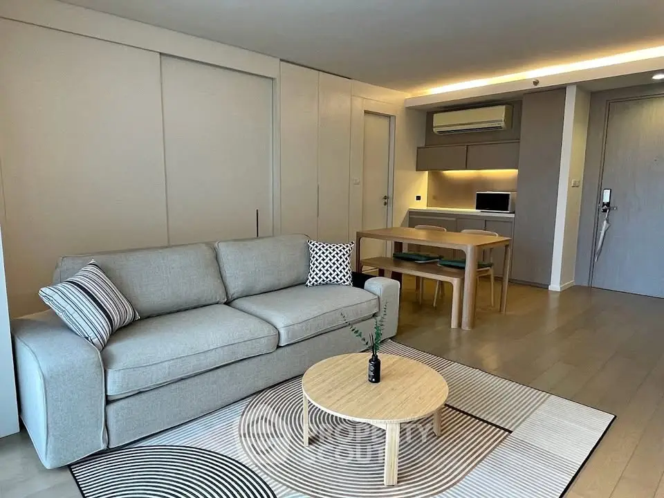 Modern living room with stylish furniture and open kitchen layout in a contemporary apartment.