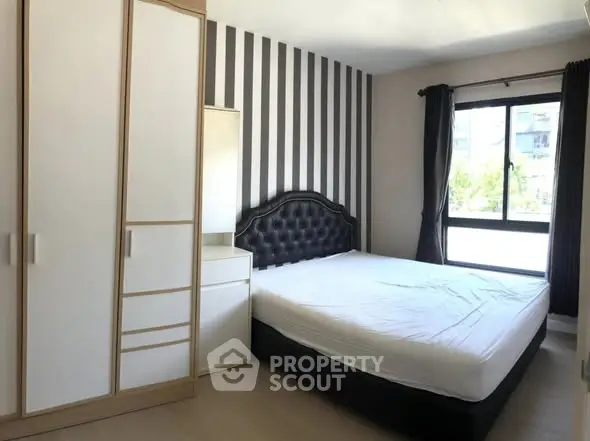 Modern bedroom with striped accent wall and large window view