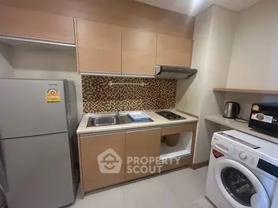 Modern kitchen with sleek appliances and stylish backsplash in cozy apartment