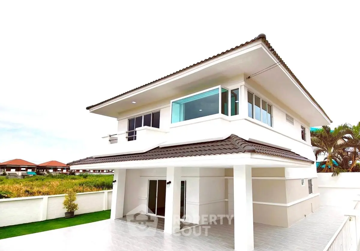 Modern two-story house with sleek design and spacious balcony in a serene neighborhood.