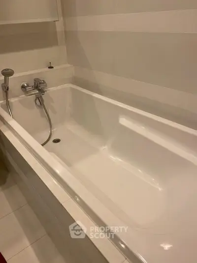 Modern bathroom with sleek white bathtub and chrome fixtures, perfect for relaxation and comfort.