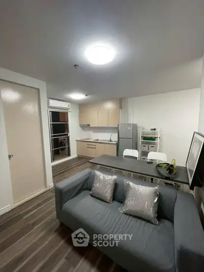 Modern open-layout living room with sleek kitchen and cozy sofa, perfect for urban living.