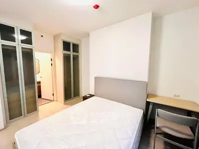 Modern bedroom with built-in wardrobe and study desk in a bright apartment.