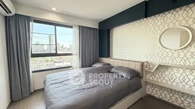 Modern bedroom with city view, featuring stylish decor and large window for natural light.
