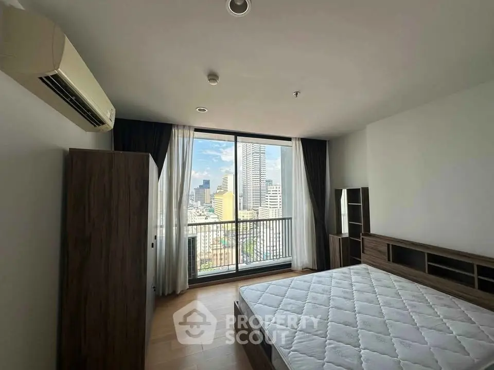 Spacious bedroom with city view and large window in modern apartment