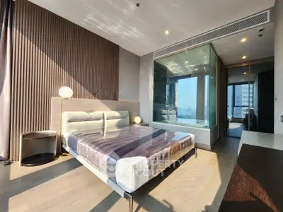 Luxurious modern bedroom with glass wall and elegant decor, featuring a plush bed and stunning city view.