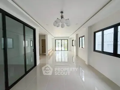 Spacious modern living room with sleek tile flooring and large windows for natural light.