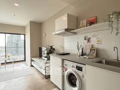 Modern open-plan living room and kitchen with city view, featuring sleek appliances and stylish decor.