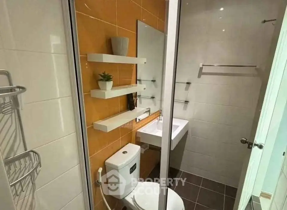 Modern bathroom with sleek fixtures and stylish shelving in a compact space.