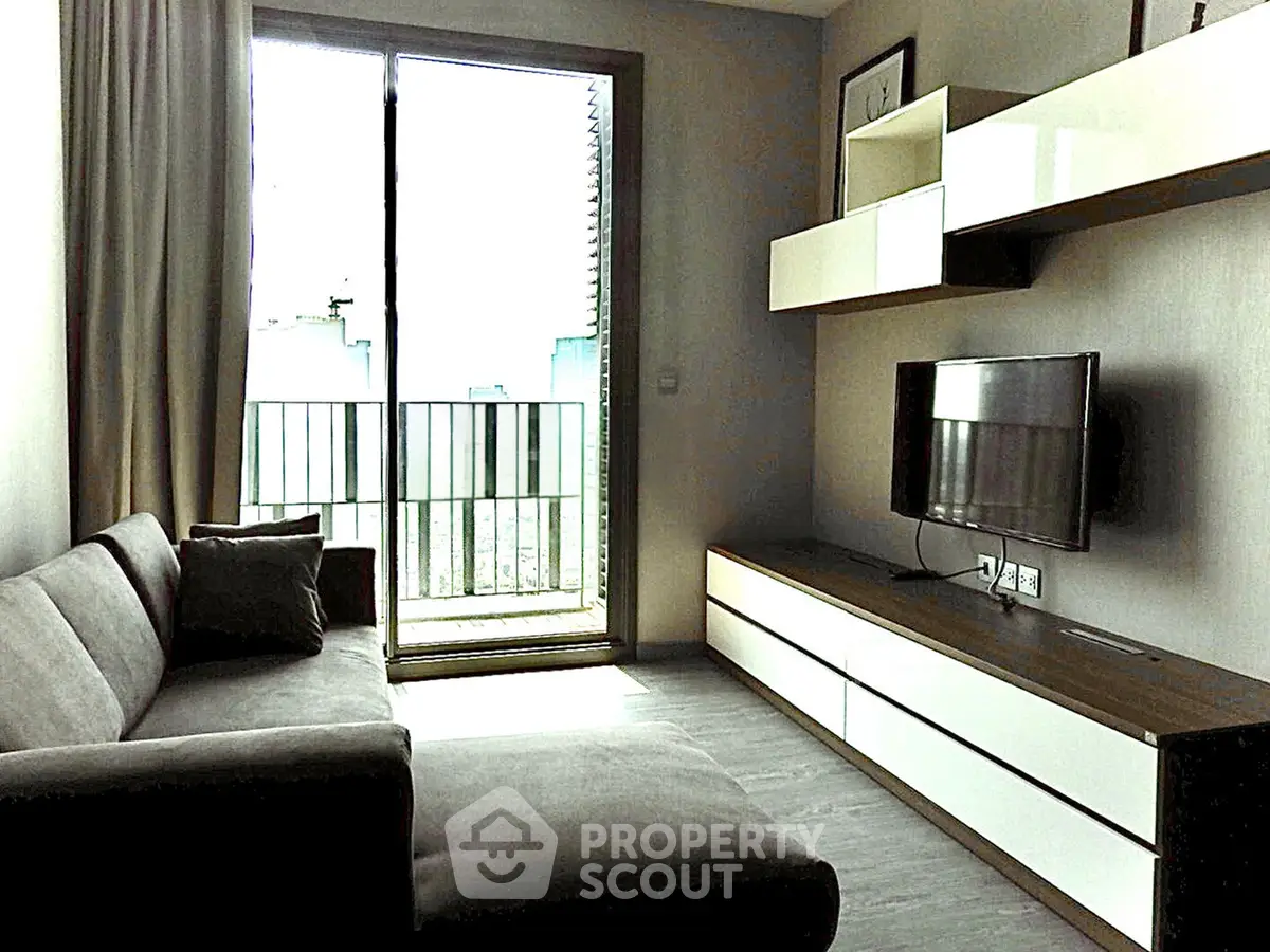 Modern living room with sleek furniture and balcony access, perfect for urban living.