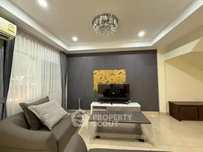 Elegant living room with modern decor and stylish lighting, featuring a comfortable sofa and a flat-screen TV.