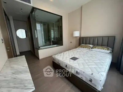Luxurious bedroom with modern design and glass-walled ensuite bathroom