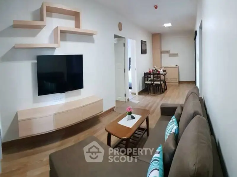 Modern living room with stylish furniture and wall-mounted TV in a cozy apartment.