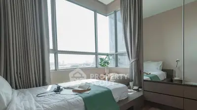 Cozy bedroom with large windows offering city views, featuring a comfortable bed and modern decor.