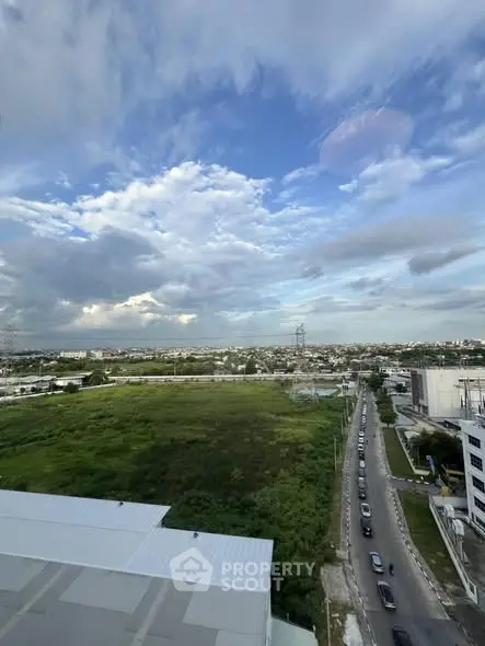 Stunning panoramic cityscape view with lush greenery and expansive sky.