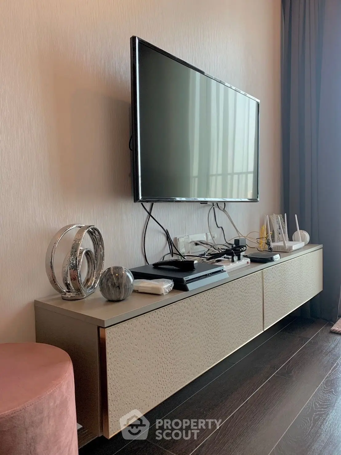 Modern living room with sleek TV setup and stylish decor on a chic console table.