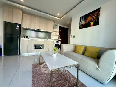 Modern open-layout living room with sleek kitchen and cozy seating area.