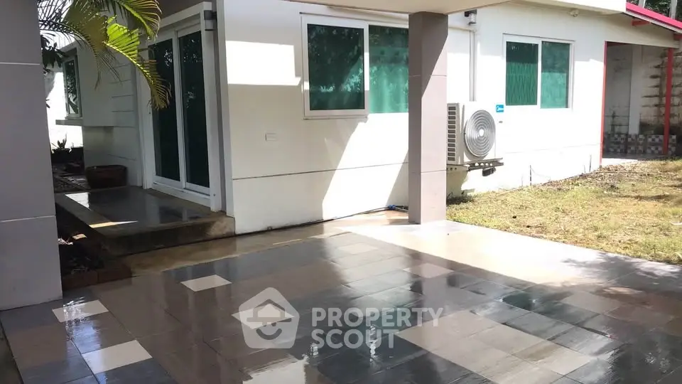 Charming single-story home with spacious tiled patio and lush garden, perfect for outdoor relaxation.