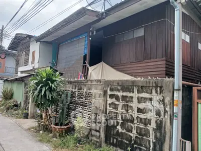 Charming rustic wooden house with a concrete fence in a quiet neighborhood.