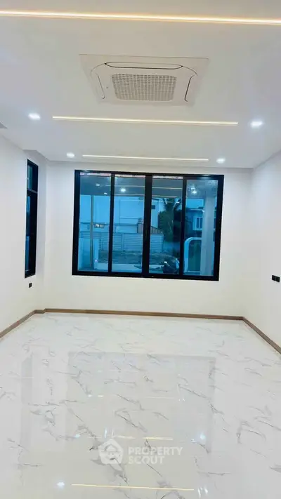 Spacious modern room with large windows and marble flooring, perfect for natural light and elegant living.