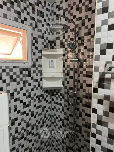 Modern bathroom with stylish black and white mosaic tiles and rainfall showerhead.