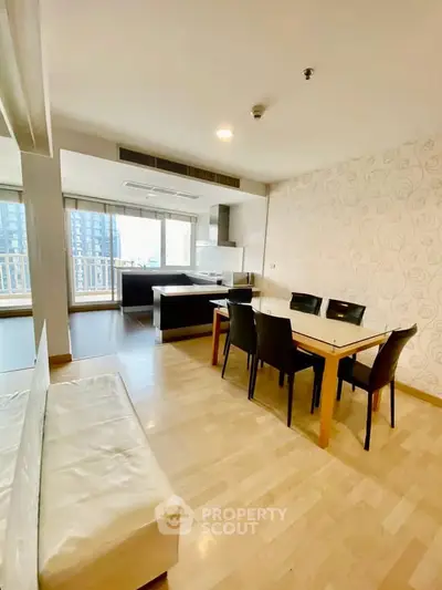 Spacious open-plan living and dining area with modern decor and city view balcony.