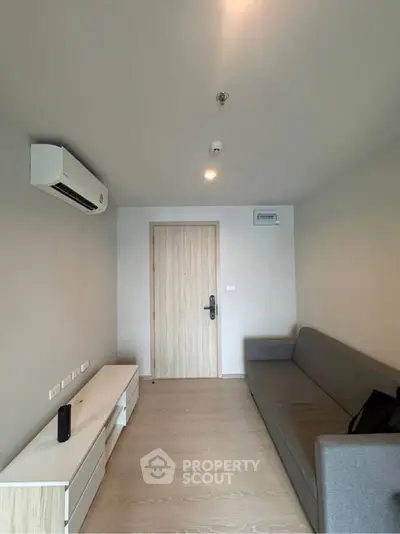 Modern minimalist living room with sleek furniture and air conditioning.