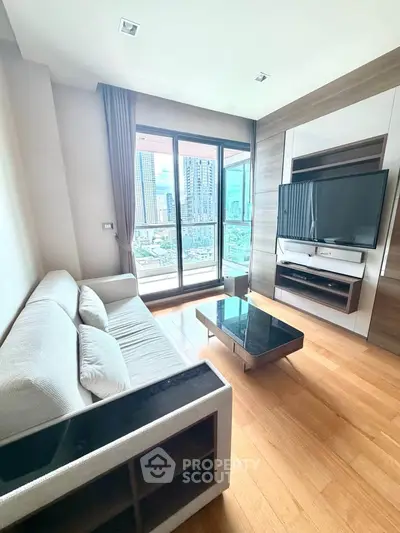 Modern living room with city view, featuring sleek furniture and large windows for natural light.