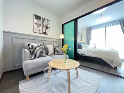 Modern living room with cozy sofa and stylish decor adjacent to a bright bedroom.