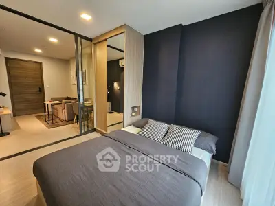 Modern bedroom with stylish decor and sliding glass doors leading to a cozy living area.