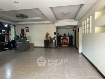 Spacious open-plan living area with modern ceiling design and ample natural light.