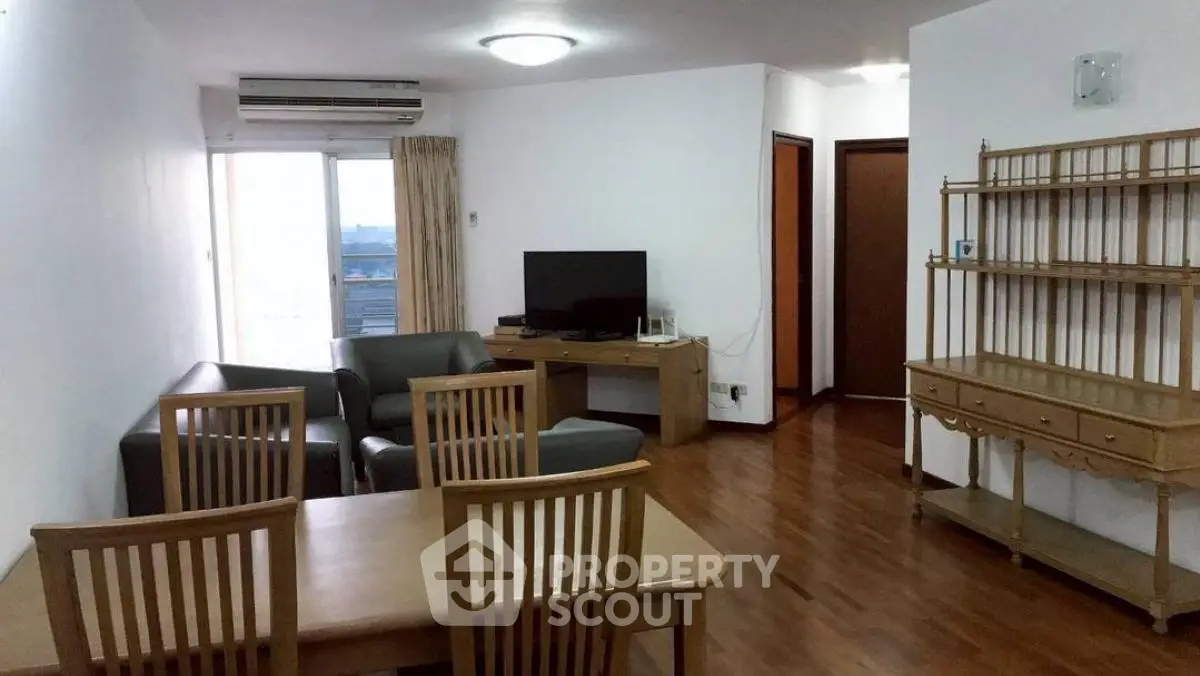 Spacious living room with modern furniture and wooden flooring, ideal for comfortable living.