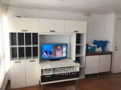 Modern living room with stylish entertainment center and TV, perfect for relaxation and entertainment.