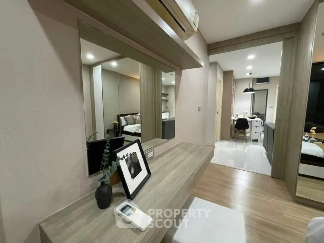 Modern bedroom with stylish decor and open layout leading to kitchen area.