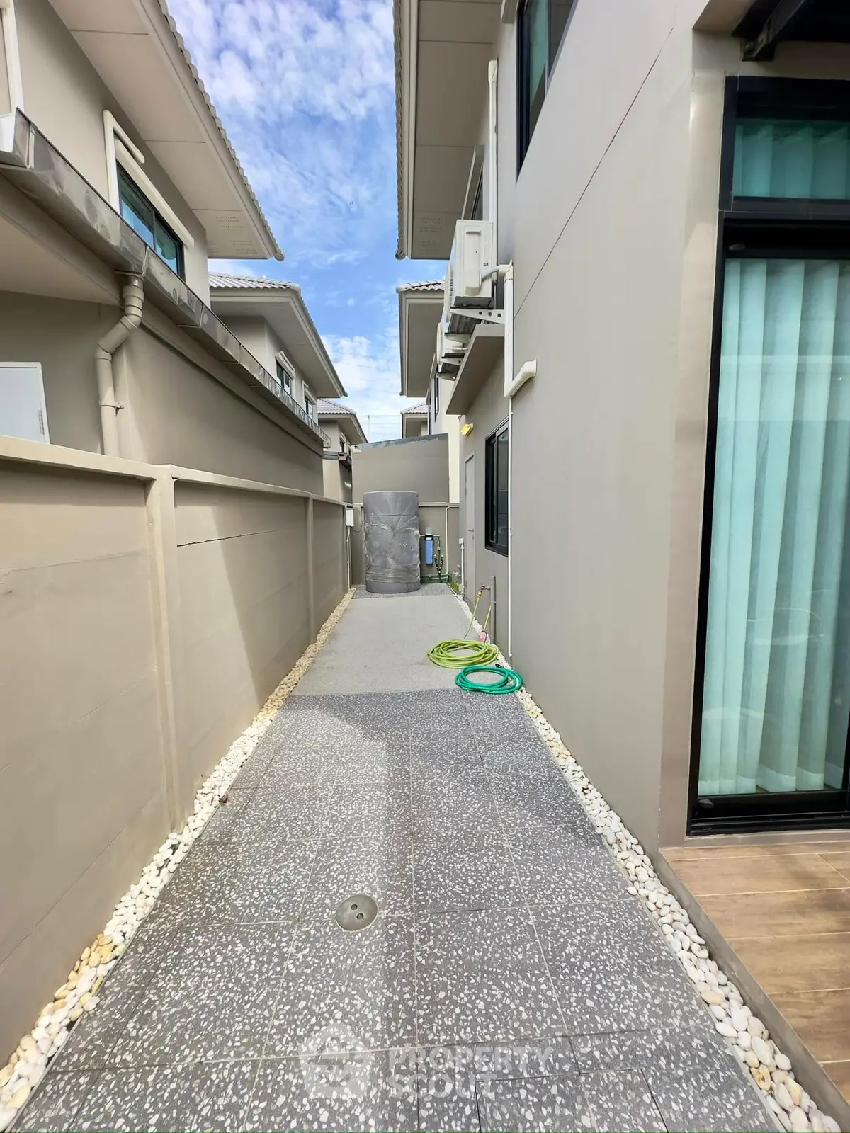 Modern exterior walkway beside contemporary home with clean design and neutral colors.