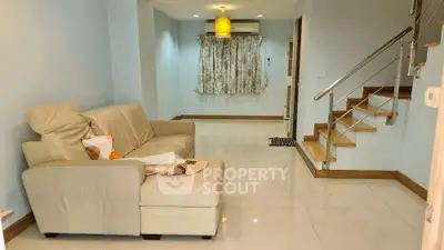 Cozy living room with modern staircase and comfortable seating