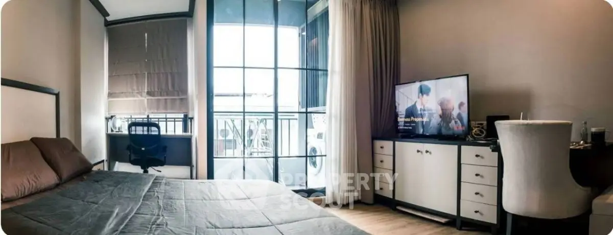 Modern bedroom with large window and TV, featuring stylish decor and comfortable furnishings.